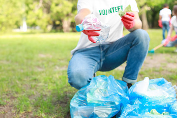 Male volunteer gathering garbage in park © Pixel-Shot