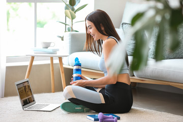 Female sport blogger with laptop at home
