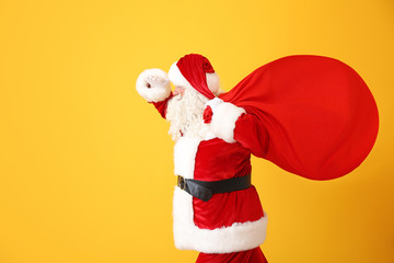 Portrait of Santa Claus with bag on color background