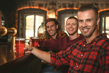 Friends drinking fresh beer in pub