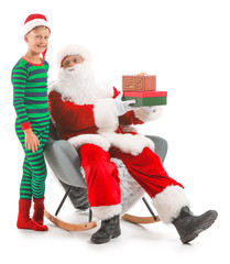 Santa Claus and little elf kid with gifts against white background