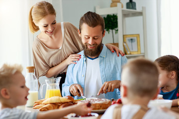 family mother father and children have Breakfast in kitchen in morning