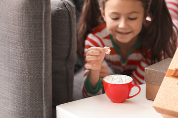 Little girl drinking hot chocolate at home