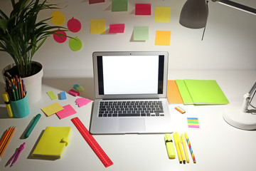 View of comfortable workplace with laptop in evening