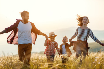 Happy family: mother, father, children son and daughter on sunset