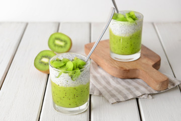 Glasses with tasty kiwi dessert on white table