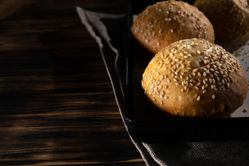 Homemade buns on burlap on wooden background