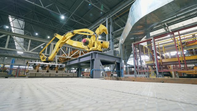 Industrial Robot is transporting bricks at factory. Timelapse.