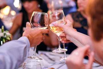 clinking of glasses at a party, white wine and champagne, fun of a big company