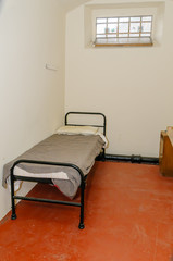 Fototapeta na wymiar Bed in a small jail cell