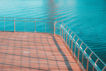 Fototapeta na wymiar Sunny image of Wooden Bridge and Metal Railing Over Providence River in Rhode Island with Teal and Orange Color Grading