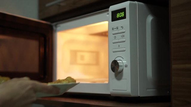 Cooking In The Microwave Oven. Putting Food Into The Microwave