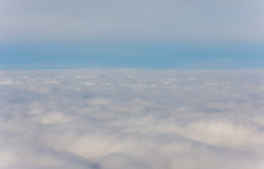 Beautiful view from plane window.  Blue sky and white fluffy clouds.