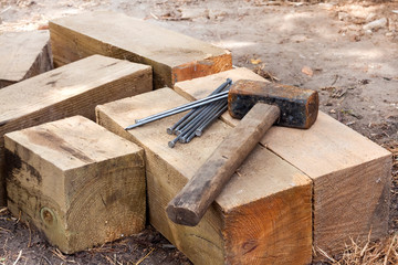 Vintage old rusty hammer and nails lying on wooden bars