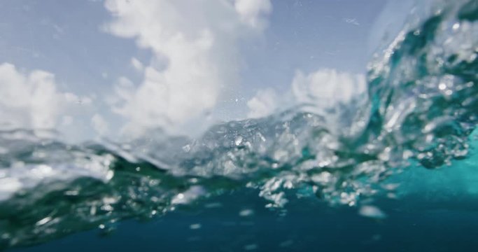Underwater shot looking out from the back of a barreling wave toward island mountains, amazing clear underwater ocean wave barrel, surfers paradise
