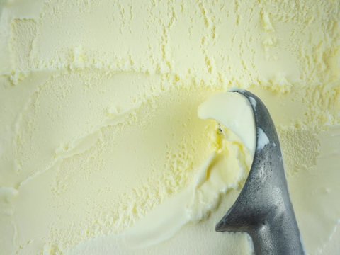 Closeup Vanilla ice cream scooped out from container with a spoon, Top view Food concept, Full HD.
