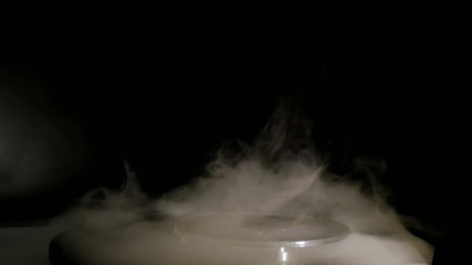 Optical, physics, experiment and technology concept. Interactive exposition in science museum, exhibition - portable smoke tornado machine with dynamic illumination light in dark room - close up view