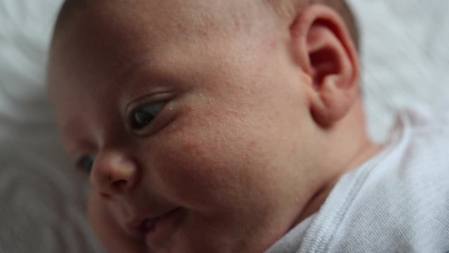 Closeup of baby newborn face laying in bed