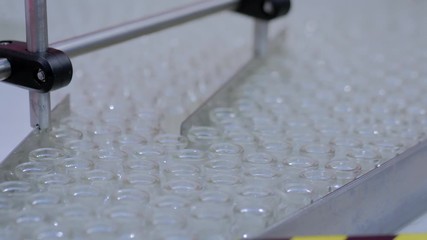 Pharmaceutical automatic production line machine conveyor with empty glass bottles at pharmacy processing factory. Pharma industry, medicine, manufacturing and automated technology equipment concept