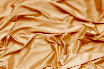 Obraz premium gold beautiful satin fabric draped with soft folds, silk cloth background, close-up, copy space