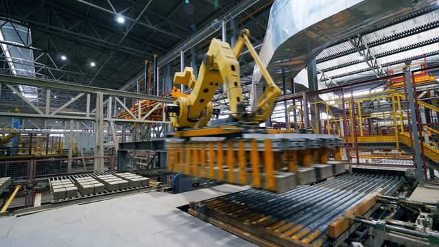 Factory equipment transporting bricks. Automatic robot manipulator in factory.