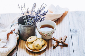 Gouter avec thé citron et biscuits sans gluten à la cannelle, fond bois vintage et pot en métal avec de la lavande