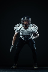 American football sportsman player in helmet on black background. Sport and motivation. Team sports.