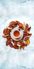Fototapeta na wymiar A cup of hot tea with fall leaves and copy space