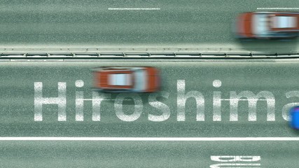 Aerial top down view of the road with cars revealing Hiroshima caption. Car travel to Japan conceptual clip
