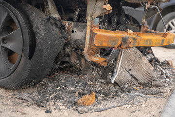 crushed melt car after deliberate arson. destroyed vehicle after a fire melted is on the street.