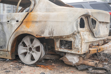 crushed melt car after deliberate arson. destroyed vehicle after a fire melted is on the street.