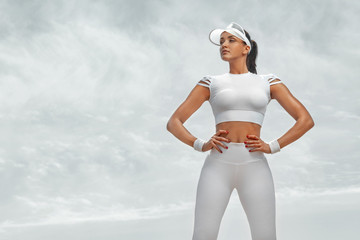 Sporty and fit young woman athlete relaxed after training at the desert. Cloudy day on coast. The...