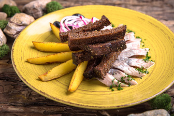 Salted Herring with potatoes, black bread and garlic. Russian appetizer to vodka