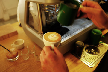Hand of barista making latte art