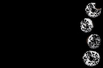 Chocolate glazed donuts on black background with copy space for text