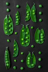 Green pea harvest on dark background. Healthy vegetarian food concept