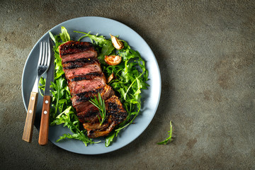 Grilled ribeye beef steak with red wine, herbs and spices. Top view with copy space for your text. Flat lay
