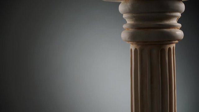 Single ancient greek column rotating slowly on dark background, copy space text area