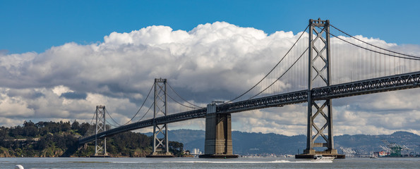 Panorama of the San Francisco bay bridge with fluffy white clouds in the background