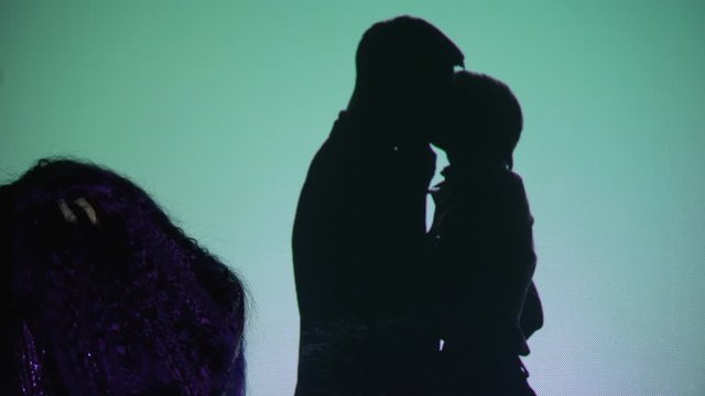 Crying woman against silhouette couple kissing background, husband betrayal