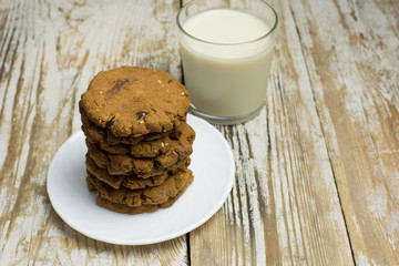 Homemade gluten-free buckwheat cookies and a glass of oat milk on a wooden background. Homemade cake. Diet Breakfast. Healthy food.