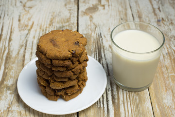 Homemade gluten-free buckwheat cookies and a glass of oat milk on a wooden background. Homemade cake. Diet Breakfast. Healthy food.