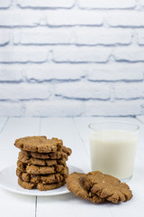 Homemade gluten-free buckwheat cookies and a glass of oat milk on a wooden background. Homemade cake. Diet Breakfast. Healthy food.