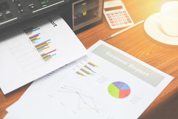 printer printing business reports sale and pile of documents report graph chart on table at office