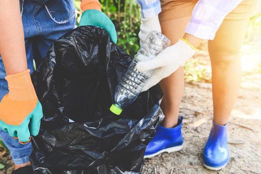 Group Of Young Women Volunteers Helping To Keep Nature Clean And Picking Up The Garbage Plastic Bottle From Park - Recycling And Waste Reduction Techniques That Help The Environment