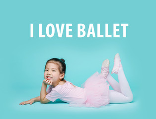 Beautiful smiling Asian little girl in a pink suit is dancing a ballet at school, empty space in...