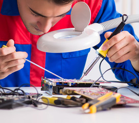 Professional repairman repairing computer in workshop