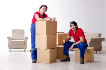 Two young contractor employees moving personal belongings