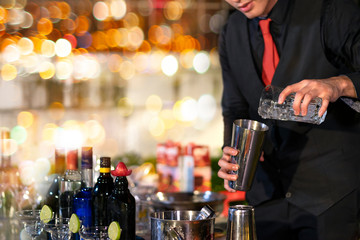 High ISO.Bartender mixed drinks, cocktails at the outdoor bar at night.Night bokeh