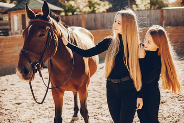 Obraz premium Girls with a horse. Women in a ranch. Blonde in a black sweater